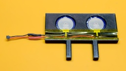 The printed frame, with two supercapacitors placed inside. The contacts are covered with kapton tape.